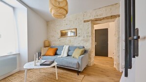 Un salón moderno con un sofá azul claro, una mesa de centro blanca y una lámpara de pie de fibras naturales.