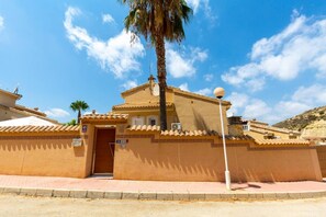 A building with a traditional architectural style, featuring a tiled roof and a door with a sign above it. - The Big Chill by Fidalsa (Ciudad Quesada)
