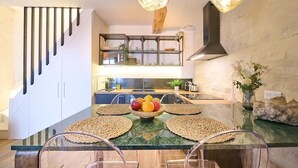Una cocina moderna con una isla central, horno empotrado y una lámpara colgante.