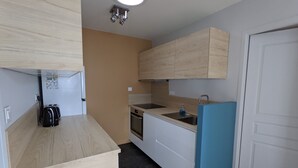A compact kitchen with a wooden countertop, a sink, a stove, and a refrigerator. - Nice little house close to the sea and town center (La Rochelle)