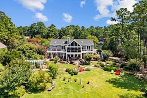 A large, two-story house with a covered porch and a well-maintained garden.