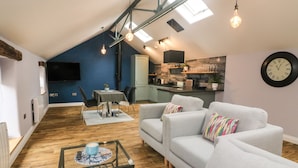 Un moderno apartamento tipo loft con comedor, cocina y sala de estar.
