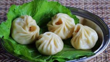 Un plato de dumplings sobre una cama de hojas de lechuga.