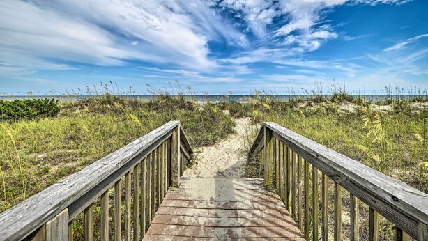 A wooden boardwalk leading to a beach with a clear sky and clouds. - Myrtle Beach Condo w/ On-Site Pool & Beach Access (Myrtle Beach)