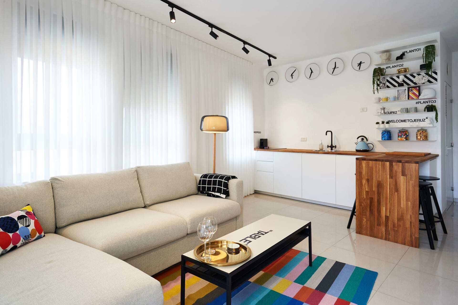 Ein modernes Wohnzimmer mit einer Couch, einem Couchtisch und einer Küchenzeile mit einer Bar.