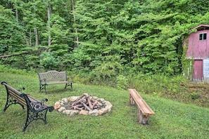 Situated in a serene countryside setting, this space offers a fire pit and benches for relaxation.