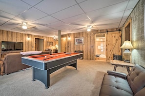 Relax in this inviting room featuring a pool table, comfortable seating, and a TV.