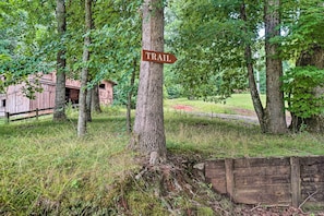 Explore the serene surroundings of this countryside retreat, where a rustic trail beckons through lush greenery.