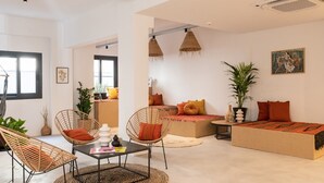Un salon moderne avec des meubles en osier, un ensemble de canapés et une table basse.