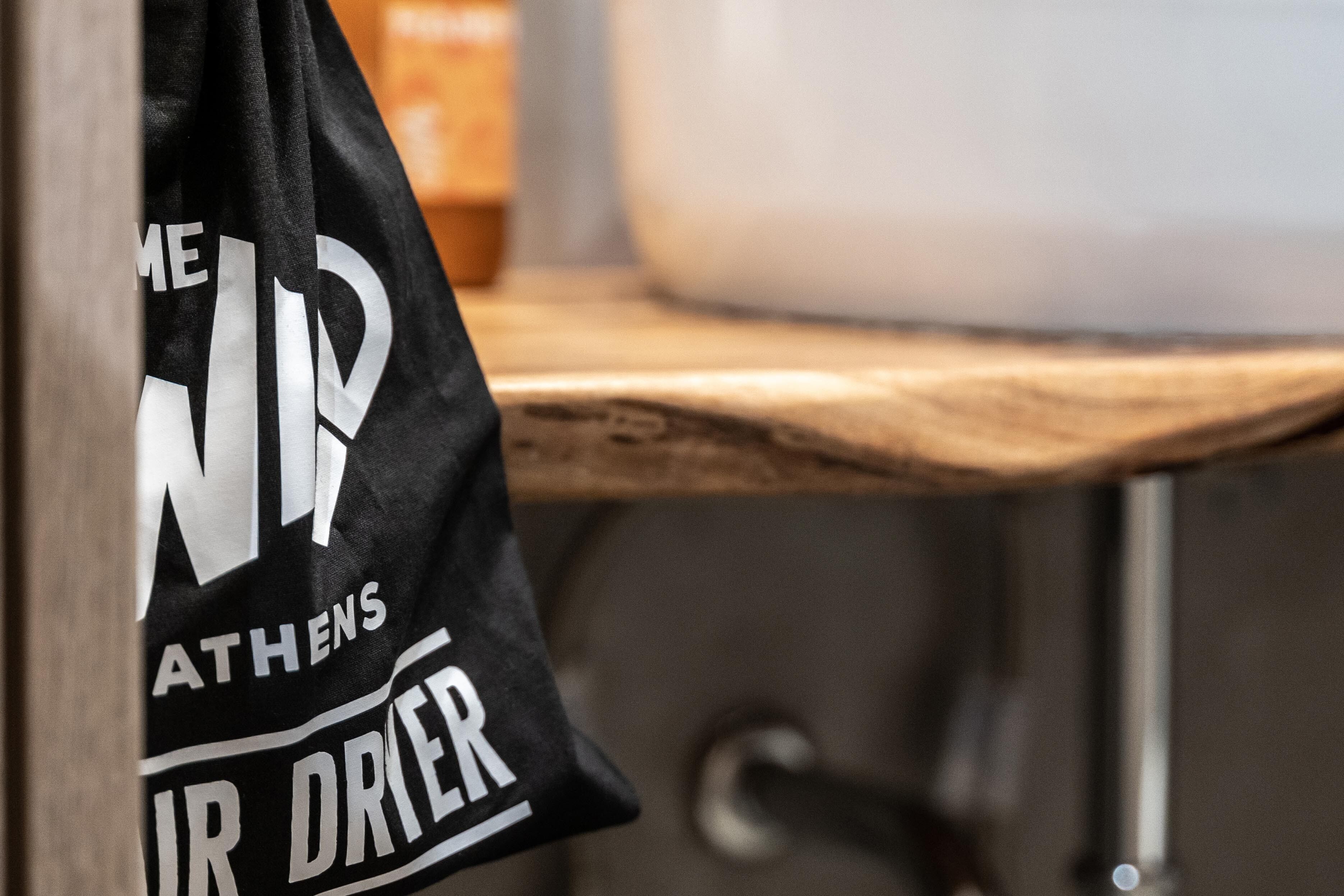 A black bag with white text hanging on a hook.