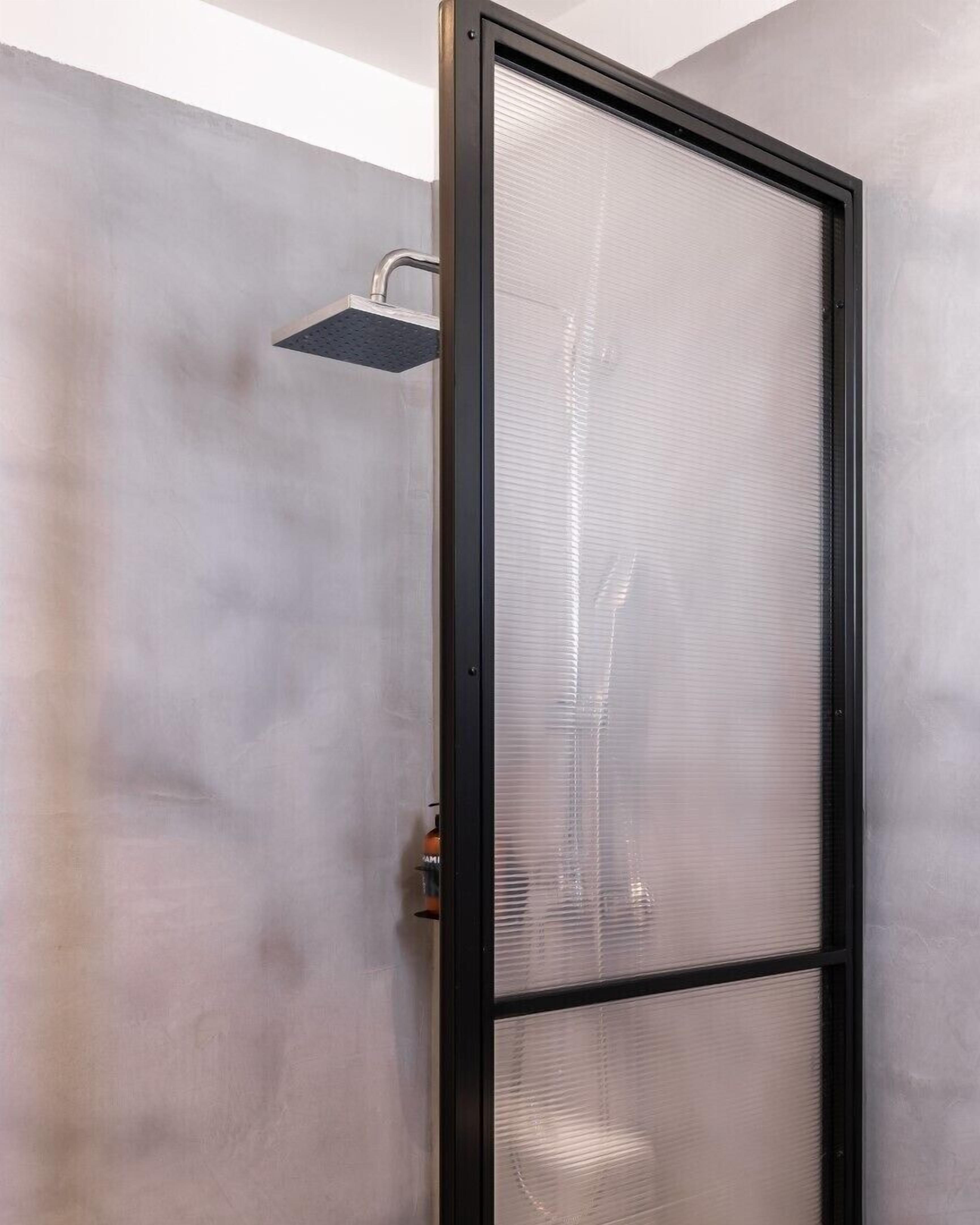 A shower enclosure with a frosted glass door and a showerhead.