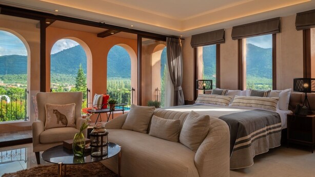 A spacious bedroom with a large bed, a sofa, and a view of the mountains. - Toscana Valley Castello Della Valle (Pak Chong)