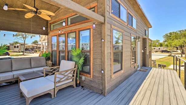 A modern house with a deck, large windows, and a ceiling fan. - Upscale Tiny Home - Boho-Chic Austin Getaway! (Austin)