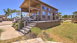 A two-story house with a covered porch, a staircase, and a driveway. - Upscale Tiny Home - Boho-Chic Austin Getaway! (Austin)