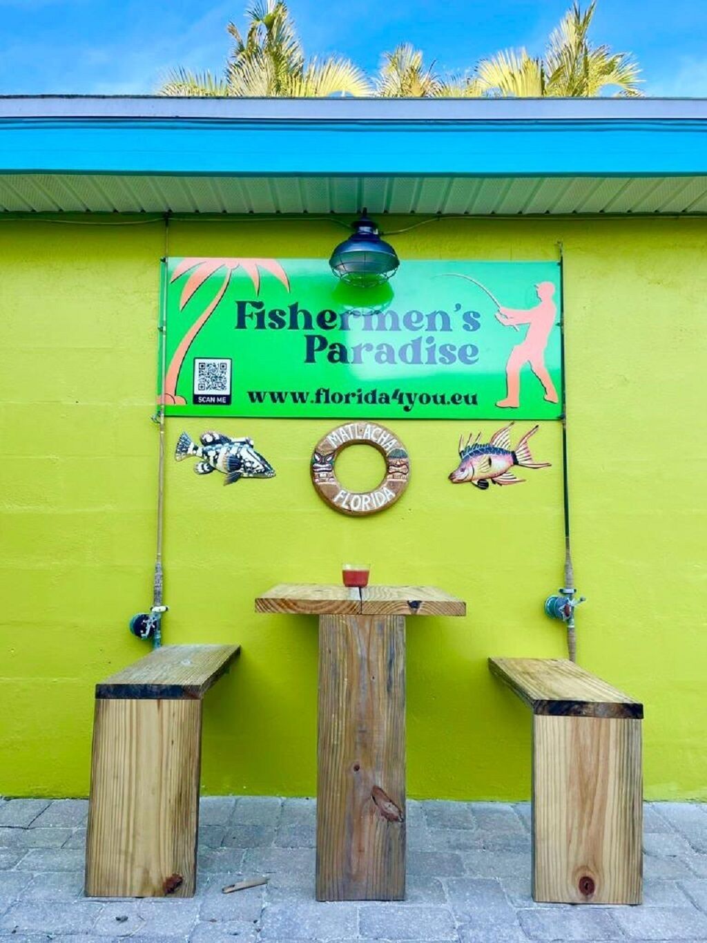 Una mesa de madera con un cartel que dice "Fishermen's Paradise" y una dirección web.