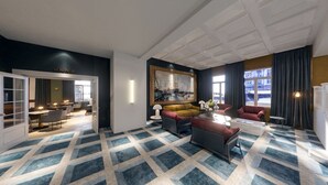 Un rebedor d'hotel modern amb una catifes de disseny geomètric, un quadre gran emmarcat i una zona de seients amb un sofà i butaques.