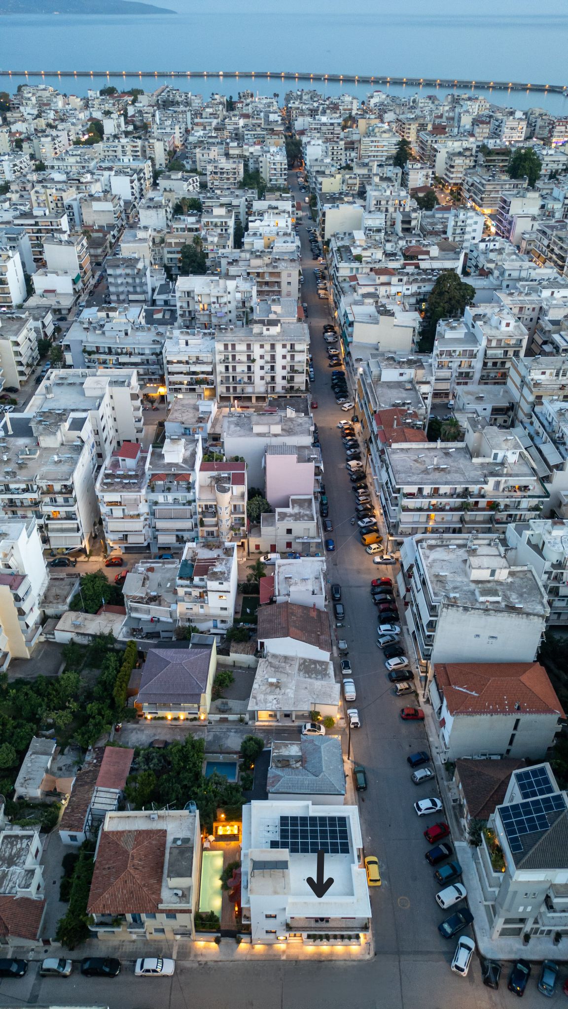 An aerial view of a densely packed urban area with a prominent road running through the center.