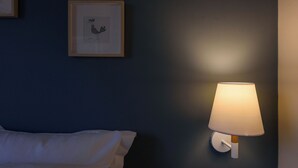 A room with a bed, a framed picture on the wall, and a wall-mounted lamp. - Thalias Quarters - Kalamata Mediterranean Suites & Villas (Kalamata)