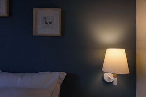 A room with a bed, a framed picture on the wall, and a wall-mounted lamp. - Thalias Quarters - Kalamata Mediterranean Suites & Villas (Kalamata)