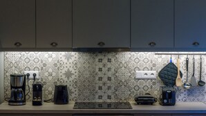 A kitchen with a coffee maker, toaster, and electric kettle on the counter. - Thalias Quarters - Kalamata Mediterranean Suites & Villas (Kalamata)
