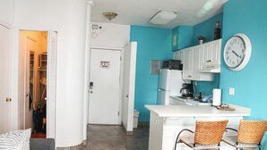 A kitchen with white cabinets, a microwave, and a clock on the wall. - Heart of South Beach ¤ 2 min Plage ¤ Ocean Drive (Miami Beach)