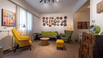 A modern living room with a sofa, chairs, a coffee table, and a wall decorated with plates.