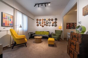 A modern living room with a sofa, chairs, a coffee table, and a wall decorated with plates.