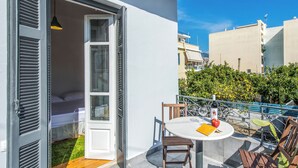 Ein Balkon mit einem Bett, einem Tisch mit einer Flasche und einem Apfel, sowie einem Stuhl.