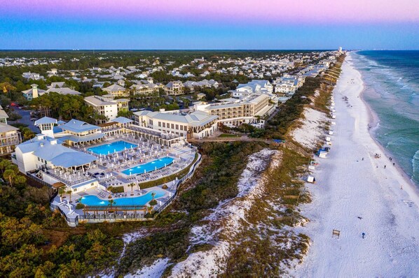 An aerial view of a coastal resort with a large swimming pool, beachfront properties, and a beach. - Heated Pool with Sitting Spa and LSV (Santa Rosa Beach)