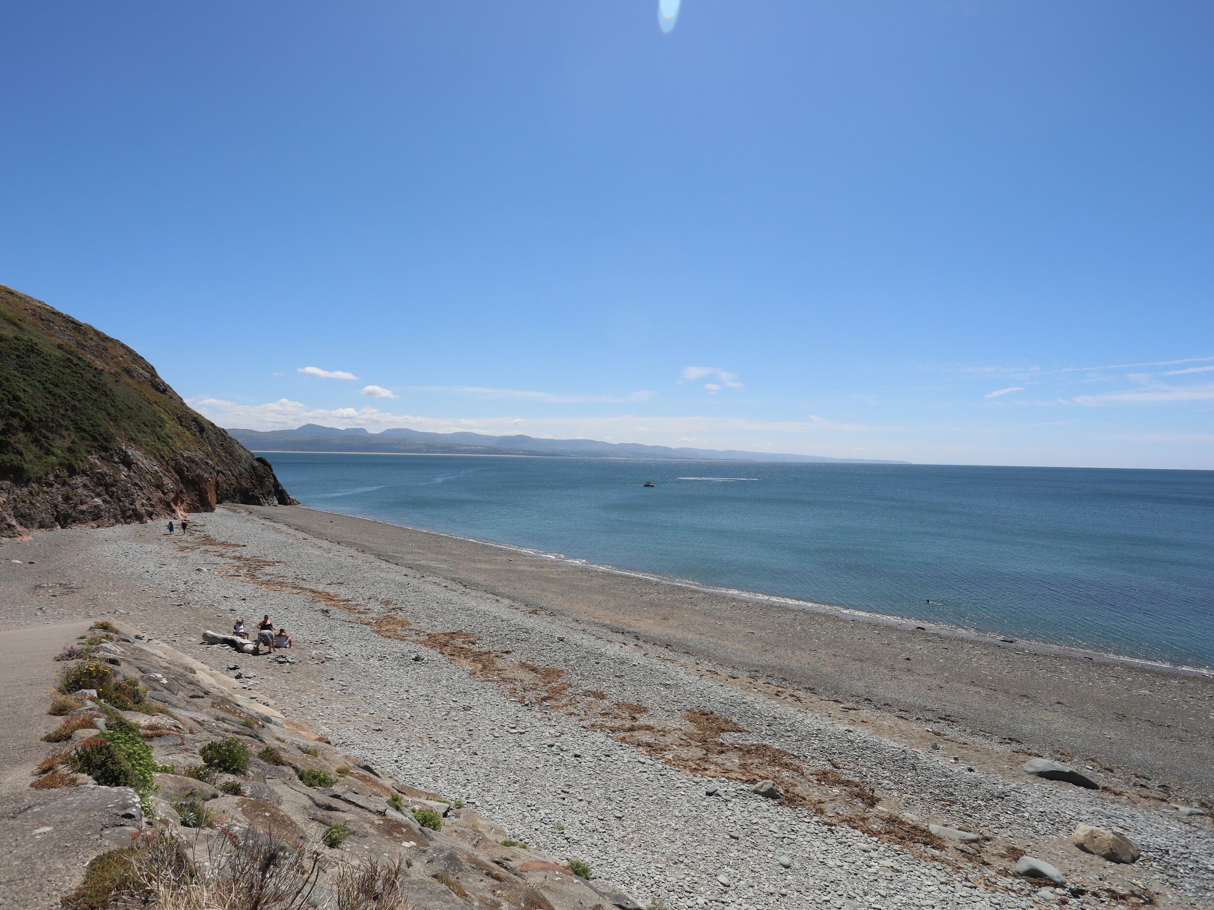 Una playa costera con terreno rocoso y una vista despejada del mar.