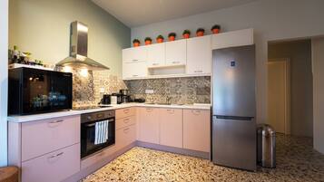 A modern kitchen with white cabinets, a stainless steel refrigerator, and a patterned backsplash.