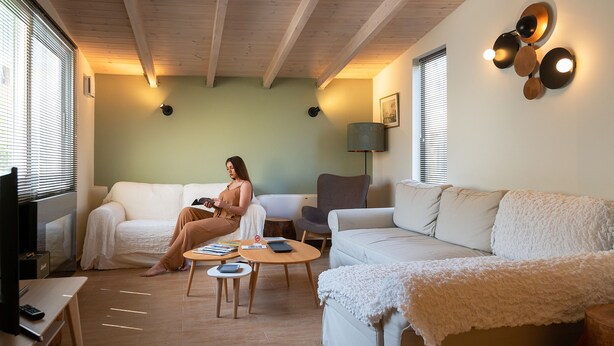 A cozy living room with a sofa, a coffee table, and a TV. - Tinas Home - Kalamata Mediterranean Suites & Villas (Kalamata)