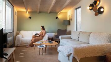 A cozy living room with a sofa, a coffee table, and a TV.