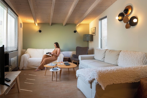 A cozy living room with a sofa, a coffee table, and a TV.