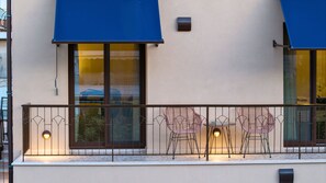 A building with a balcony featuring metal railings and two tables with chairs. - Tinas Home - Kalamata Mediterranean Suites & Villas (Kalamata)