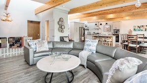 A modern living room with a curved grey sofa, a round coffee table, and a wooden ceiling. - Trails End Vacation Home At Windcliff 3 Bedroom Home by RedAwning (Estes Park)