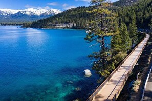 Enjoy a serene lakeside view with a scenic boardwalk and breathtaking mountain vistas.