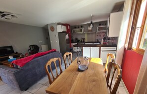 A compact living space with a dining area, kitchenette, and a sofa.