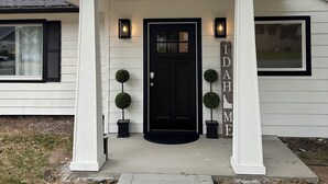 A house with a black front door, white columns, and a name sign that reads "IDAHO HOME". - CDA ID. Sanders Beach! Best Location! Newly Remodeled Addition! Pet Friendly. (Coeur d'Alene)