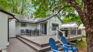 A house with a deck, outdoor seating, and a covered area. - CDA ID. Sanders Beach! Best Location! Newly Remodeled Addition! Pet Friendly. (Coeur d'Alene)