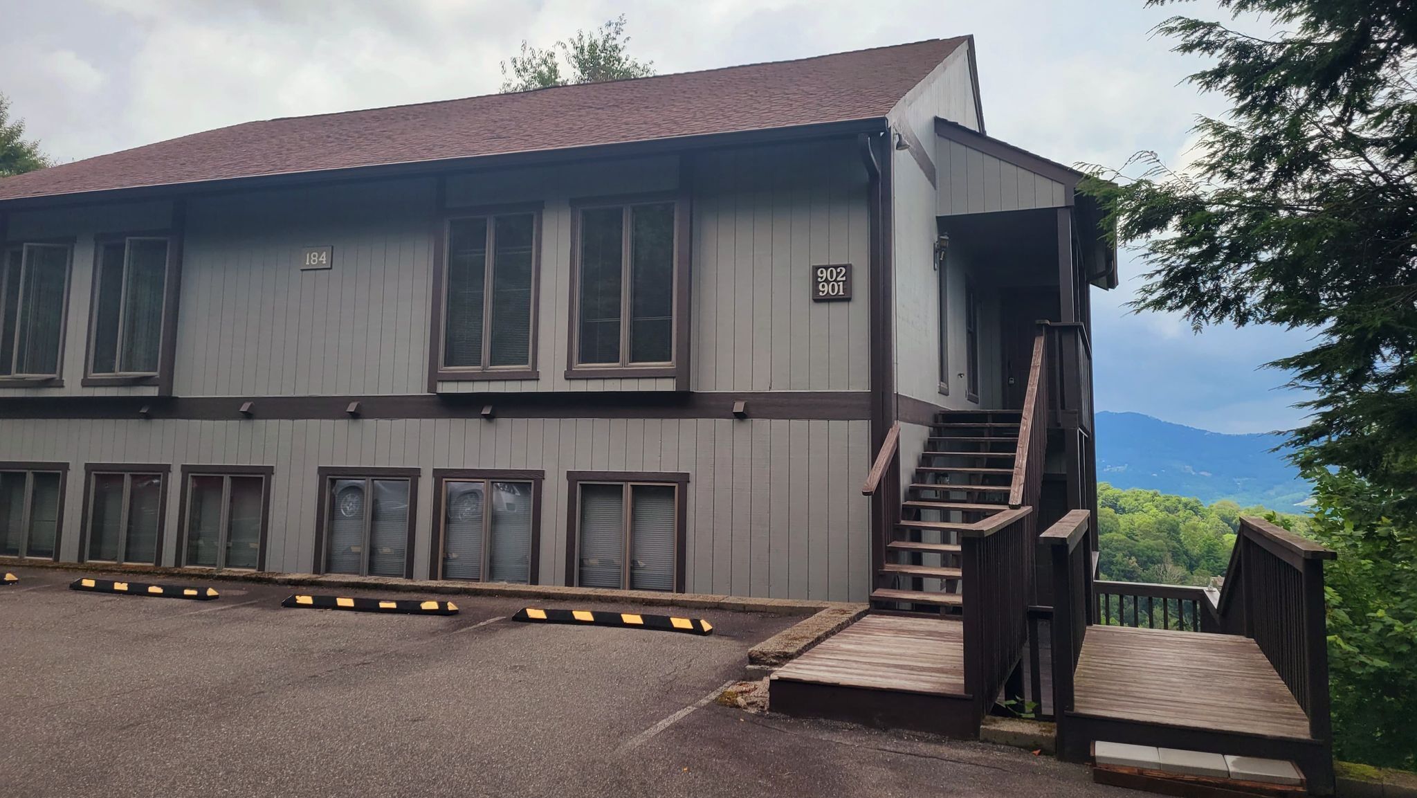 A two-story building with a staircase leading to a deck.