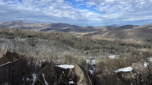 A mountainous landscape with houses covered in snow, under a partly cloudy sky. - Beautiful Sugar Mountain Condo with Long-Range Views (Sugar Mountain)