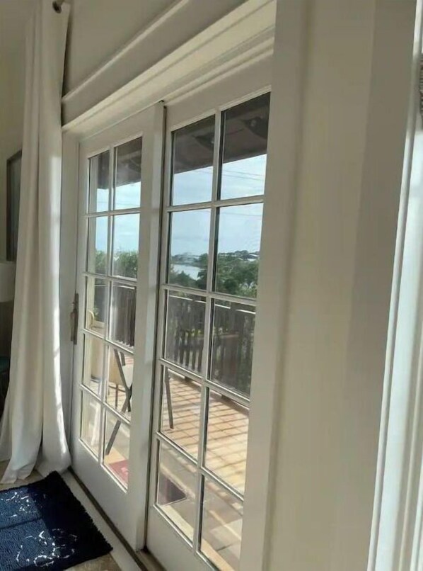 Una habitación con un amplio ventanal corredizo que da a una terraza exterior.