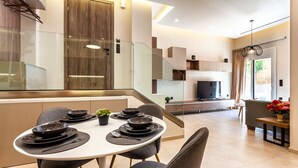 Una cocina moderna con comedor, una escalera y una sala de estar con chimenea.