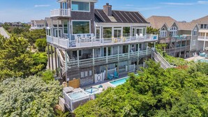 Une propriété en bord de mer, composée de plusieurs étages, dotée d’une piscine, de nombreuses terrasses et d’une tour de surveillance pour les sauveteurs.
