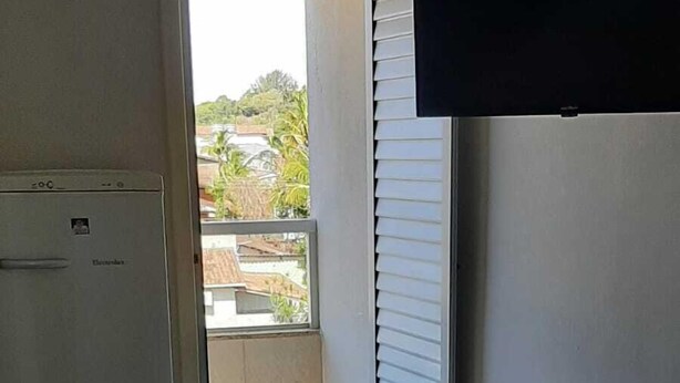Une pièce comprenant un lit, une table avec des chaises, un téléviseur et un réfrigérateur.