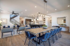 A modern kitchen with a large island, built-in appliances, and pendant lighting.