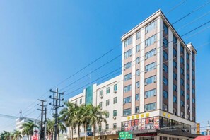 Un hôtel à plusieurs étages, doté d’une façade sobre, de nombreuses fenêtres et d’un espace commercial au rez-de-chaussée, reconnaissable à son enseigne.