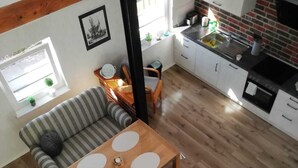 Un espacio habitable compacto con comedor, kitchenette y un sofá.