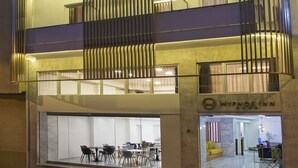 A multi-story building with a glass facade, a visible restaurant at the ground level, and a sign for 'Hypnos Lounge'. - Hypnos Inn Athens (Athens)